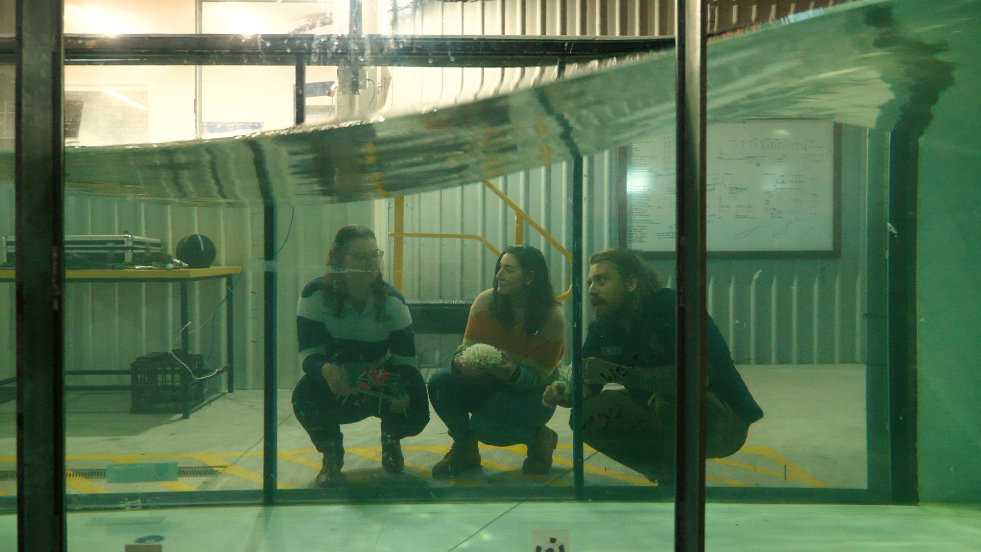 Master of Ocean Leadership students and graduate discussion wave movement in the wave flume located at the the Coastal and Offshore Engineering Lab. From left to right: Louise Richardson, Careena Nolan, Jurgen Valckenaere.