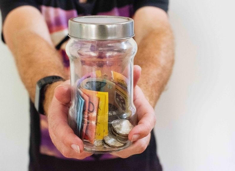 Man holding jar with money