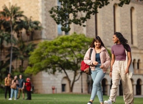 Two students walking together in front of Winthrop Hall 