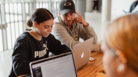 Students with laptop at table