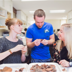archaeology students looking at artefact