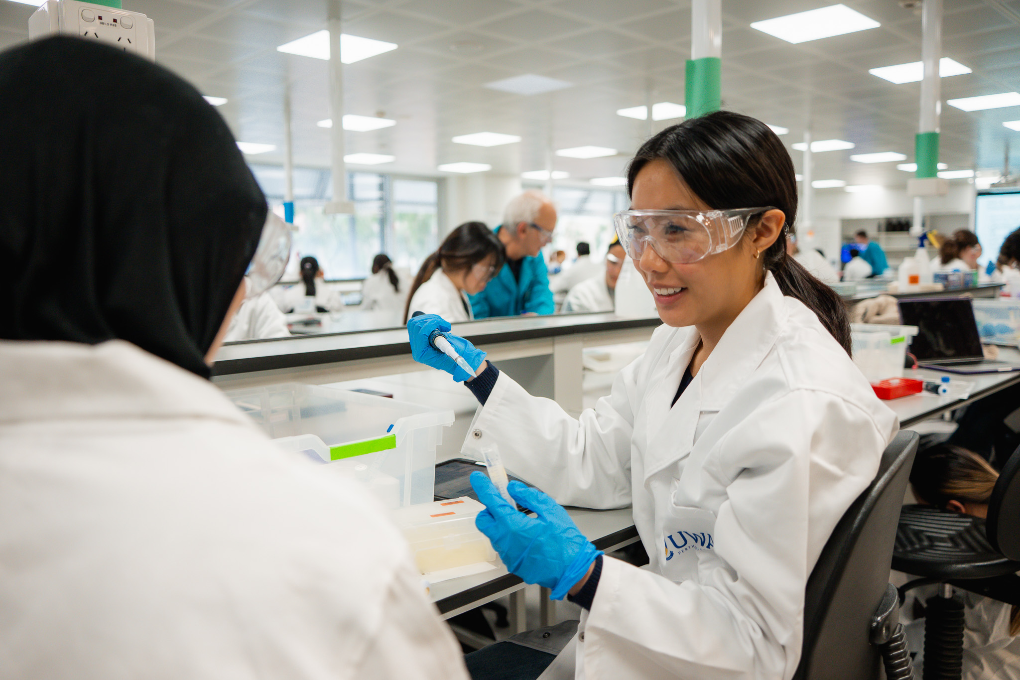 A close-up of two female students working together inside the lab.