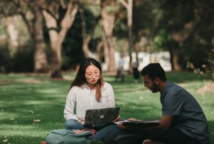 Two students sitting on grass 