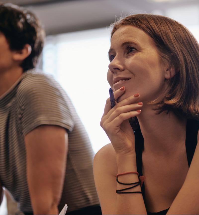 Two people listening to a lecturer 