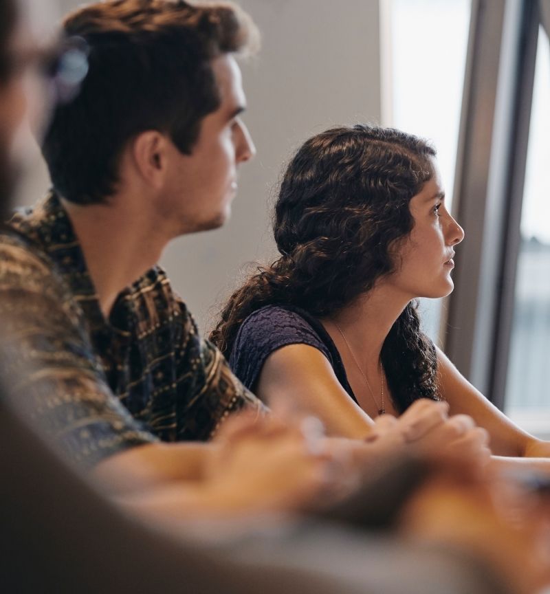 Two people listening to a presentation