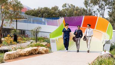 2 students walking down bridge