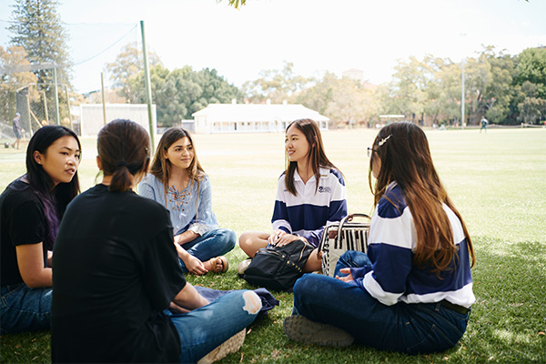 image of student sitting on james oval at UWA Perth