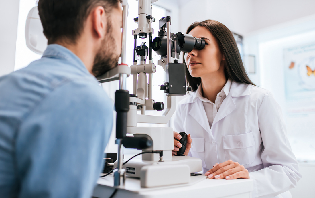 Female ophthalmologist is checking the eye vision of young man in modern clinic. Doctor and patient in ophthalmology clinic.