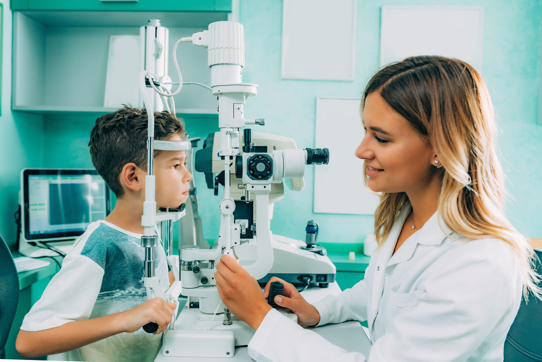Ophthalmologist examining boy with slit lamp