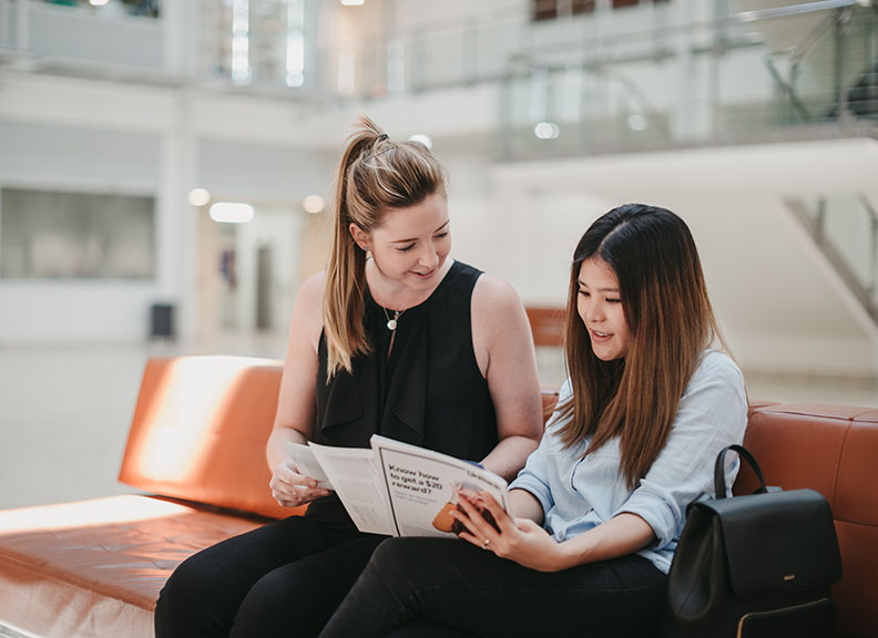 two girls reading a document