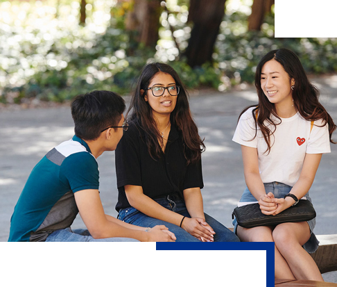 Three students sitting and talking outside