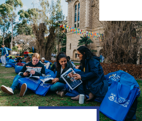 Three high school students at UWA Open Day looking at course guides