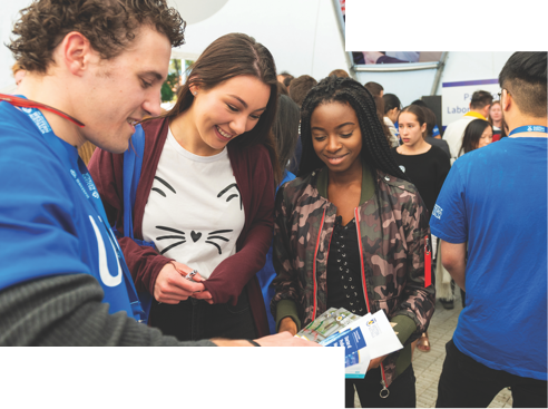 Prospective students being helped by a student adviser, who is showing them brochures.
