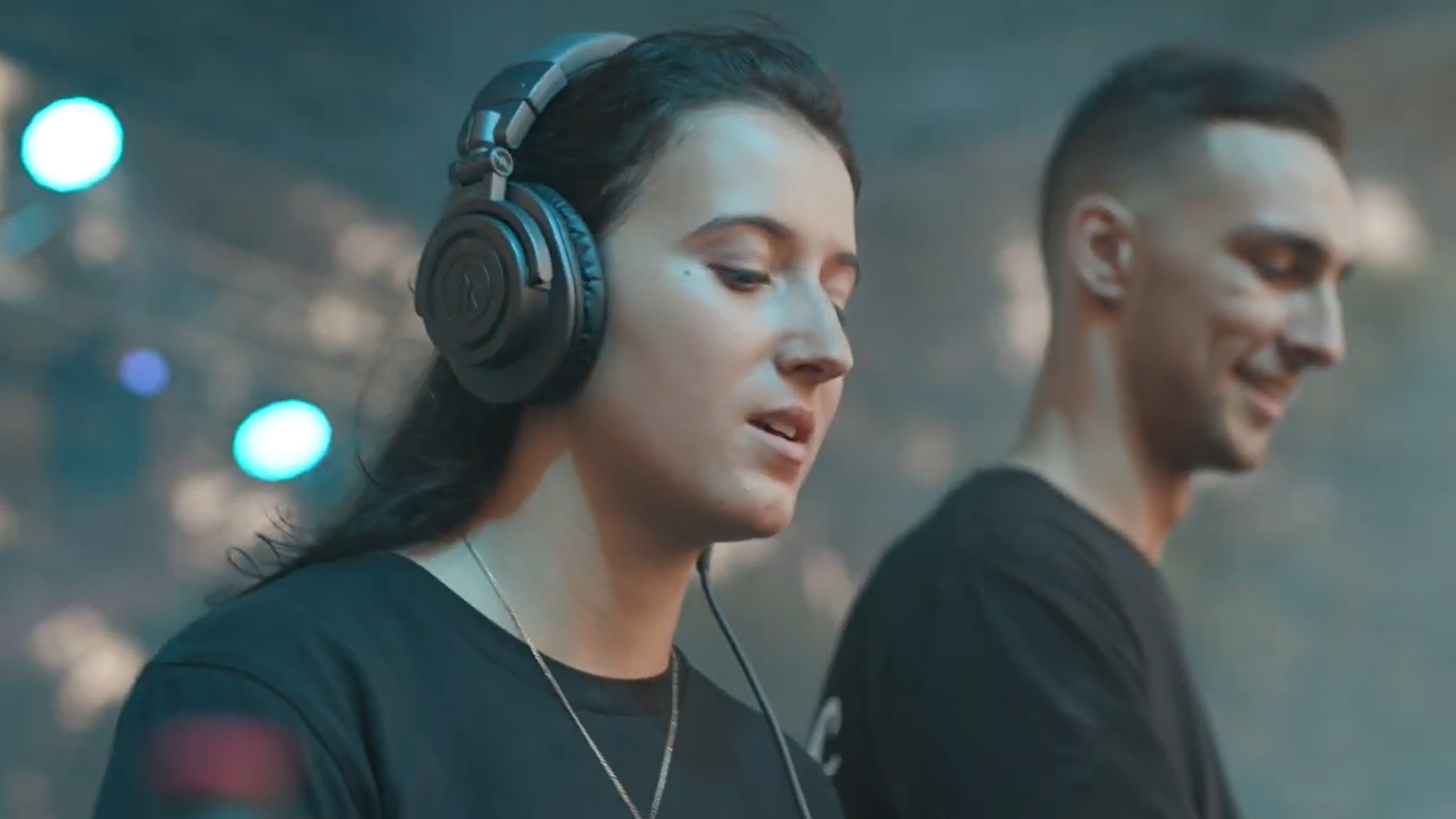 two people with headphones on playing a music set