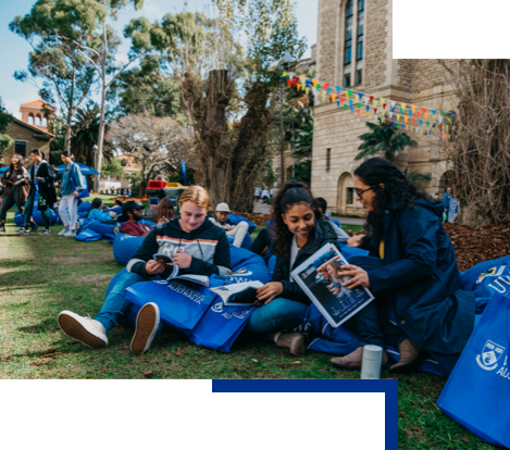 Three prospective students sit and browse brochures on beanbags